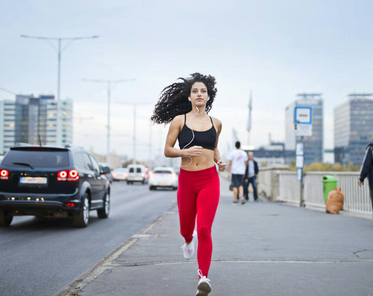 A woman in athletic gear running outdoors 