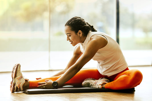 Image of a woman performing a dynamic stretching exercise, extending her leg forward with active muscle engagement, symbolizing the practice of dynamic stretching for flexibility and muscle activation.