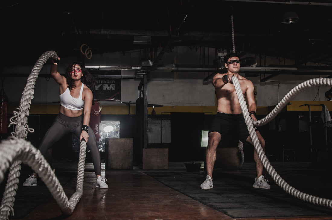 Image of a diverse pair, a man, and a woman, engaged in strength training exercises, showcasing the inclusivity of fitness for both genders.